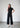 The black wide-legged pants, crafted from a ribbed fabric. Their slightly shorter length offers a contemporary twist, while the relaxed silhouette enhances comfort and style. 