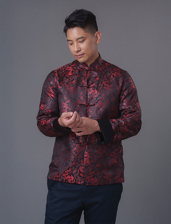 An asian Man wearing a black stain x red tiger brocade Tang Jacket against a gray background. 一位亞洲男子，以灰色為背景，穿著黑色緞面與紅色虎紋錦緞的唐裝外套。