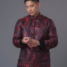 An asian Man wearing a red stain x black tiger brocade Tang Jacket against a gray background. 一位亞洲男子，以灰色為背景，穿著紅色緞面與黑色虎紋錦緞的唐裝外套。