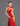 An asian woman wearing a red sleeveless satin qipao with gold phoenix embroidery on the side against a gray background.
亞洲女性，以灰色為背景，身穿紅色緞面無袖旗袍，其側面繡有金色鳳凰圖案。