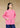 Front view, half-body shot of an Asian woman wearing a pink knitted Tang jacket by Qipology, set against a yellow-beige background.