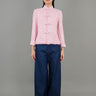 A woman stands in front, wearing a pink high-neck short-sleeved top paired with loose blue pants, showcasing a fashionable casual style.
一名女子站在正面，穿著粉紅色的高領短袖上衣，搭配寬鬆的藍色褲子，展現出時尚的休閒風格。